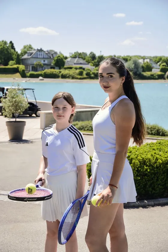 Trainerin und junge Spielerin mit Schlägern am See in der Fontana