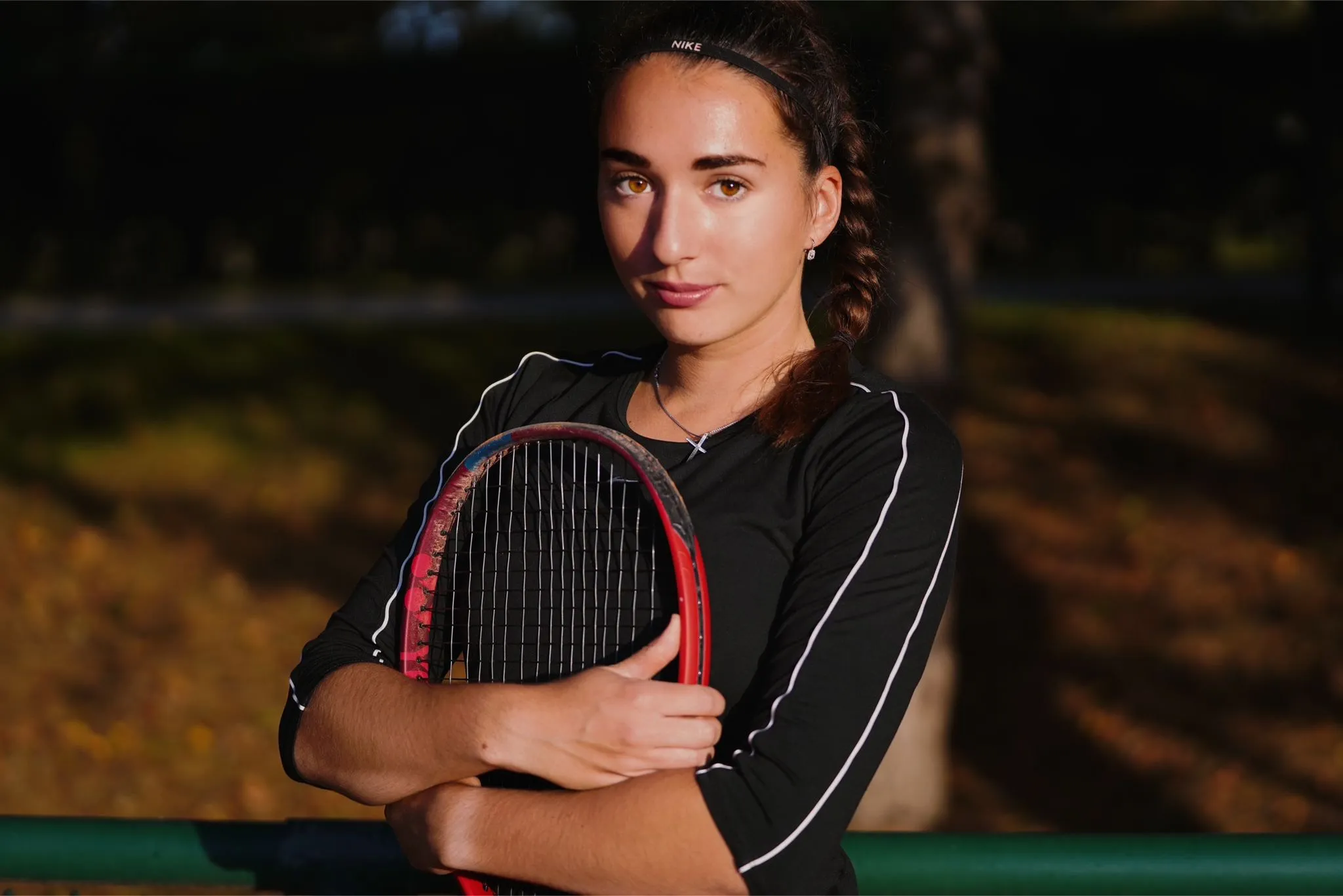Jessica Kovacs, Tennistrainerin, mit Schläger im Abendlicht